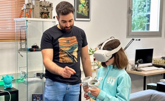 El autor de la tesis Mario Cerezo junto a una niña que lleva gafas virtuales